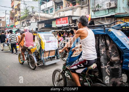 A tuk tuk or trike driver makes his way through the busy streets of the Binondo district of Manila, The Philippines. Stock Photo