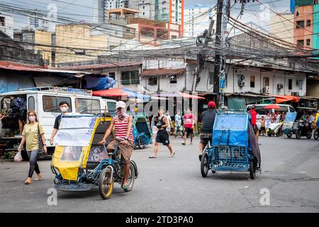 A tuk tuk or trike driver makes his way through the busy streets of the Binondo district of Manila, The Philippines. Stock Photo