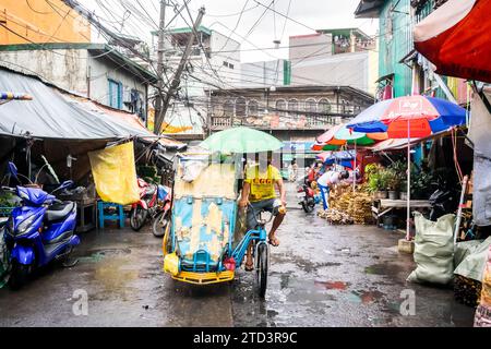 A tuk tuk or trike makes its way through the busy, tight streets of Manila, The Philippines. Stock Photo