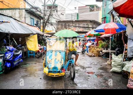 A tuk tuk or trike makes its way through the busy, tight streets of Manila, The Philippines. Stock Photo