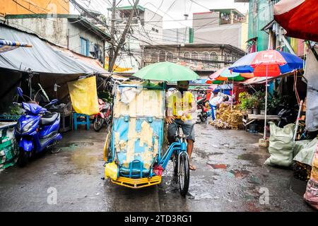 A tuk tuk or trike makes its way through the busy, tight streets of Manila, The Philippines. Stock Photo