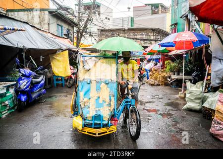 A tuk tuk or trike makes its way through the busy, tight streets of Manila, The Philippines. Stock Photo