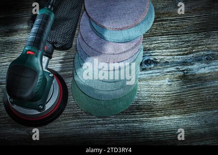 Electric orbit wood sander with sanding discs on dark vintage wooden background Stock Photo