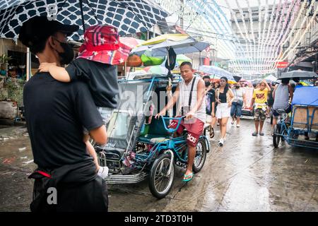 A tuk tuk or trike makes its way through the busy, tight streets of Manila, The Philippines. Stock Photo