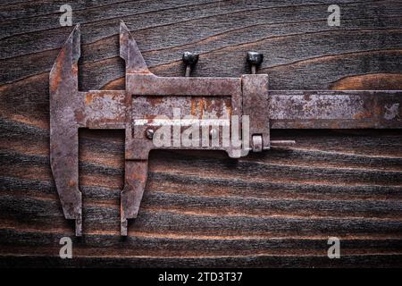 Rusted antique measuring slide caliper on vintage wooden board construction concept Stock Photo