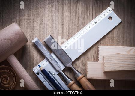 Wooden brick Hammer rolled up planning chips fixed chisel square ruler pencil on wooden board Building concept Stock Photo