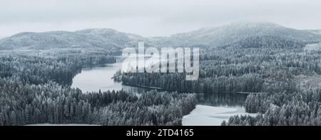 Taiga forest landscape with a lake and hills in winter Stock Photo