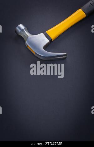 Close-up of a claw hammer with yellow and rubberised handle on a black background Stock Photo