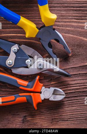 Pliers pliers and wire cutters on vintage brown wooden board construction concept Stock Photo