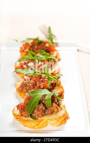 Fresh tipycal italian bruschetta with tomato and arugula on top, food photography, food photography Stock Photo