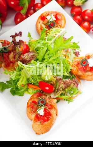 Original Italian fresh bruschetta, typical finger food, with fresh salad and vegetables on background, MORE DELICIOUS FOOD ON PORTFOLIO, food Stock Photo