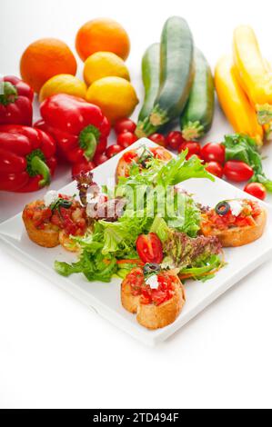 Original Italian fresh bruschetta, typical finger food, with fresh salad and vegetables on background, MORE DELICIOUS FOOD ON PORTFOLIO, food Stock Photo