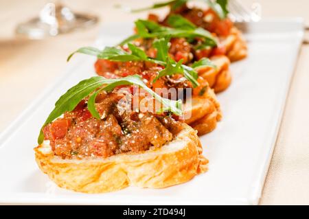 Fresh tipycal italian bruschetta with tomato and arugula on top, food photography Stock Photo