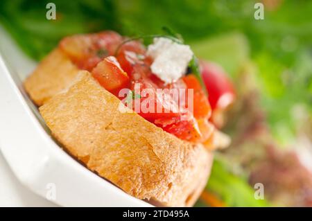 Original Italian fresh bruschetta, typical finger food, with fresh salad and vegetables on background, MORE DELICIOUS FOOD ON PORTFOLIO, food Stock Photo