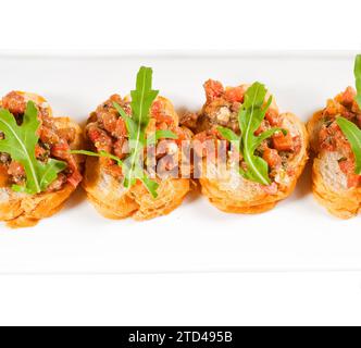 Fresh tipycal italian bruschetta with tomato and arugula on top, food photography Stock Photo