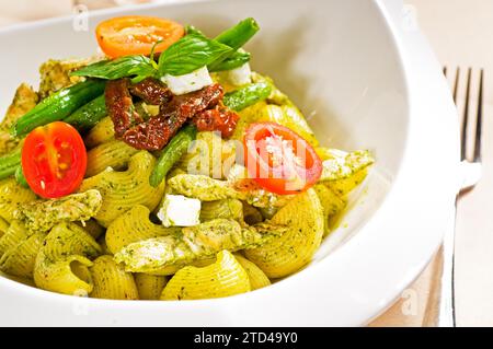 Fresh lumaconi pasta and pesto sauce with vegetables and sundried tomatoes, tipycal italian food, food photography Stock Photo