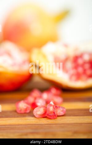 Fresh pomegranate fruit over wood cutting board, food photography Stock Photo