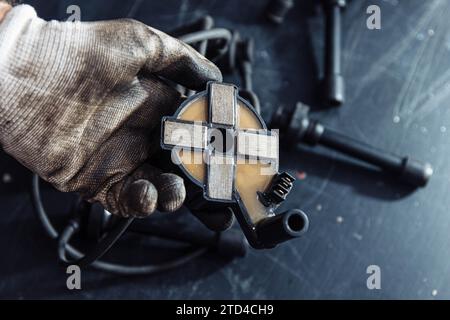 Engine ignition coil in hand of auto mechanic Stock Photo