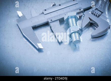 Metal brake caliper adjustable spanner bolt and nut on scratched metallic background construction concept Stock Photo