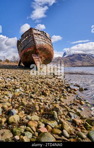 Old Boat of Caol, a shipwreck on the shore of Loch Linnhe, with views of Ben Nevis behind, Near Fort William, Scotland Stock Photo