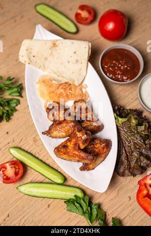 shish kebab of chicken wings on a white plate. Stock Photo