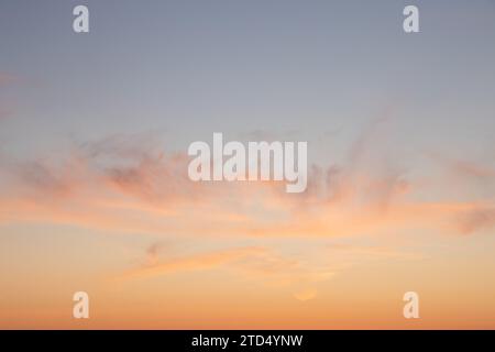 Colourful sky during sunset with reddish hues. Blue, orange and golden sky. Airplane flying over in red sun. Abstract sky. Stock Photo