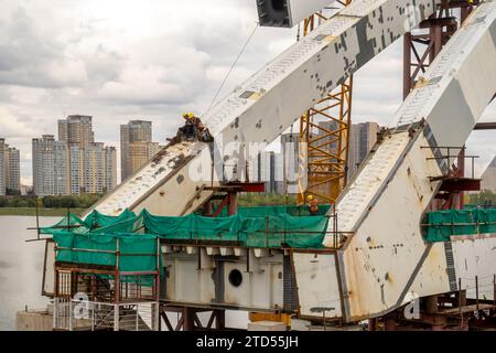 Bridge workers sitting at the bridge part under construction in Astana, Ishim river, Kazakhstan Stock Photo