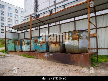 Old garbage containers stand on an equipped platform in the courtyard of the house Stock Photo