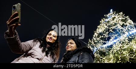 AMSTERDAM - People take photos while lighting the 40,000 lights in the Christmas tree on Dam Square. The Christmas tree is usually placed earlier in December, but this was postponed this year due to the state visit of South Korean President Yoon Suk-yeol. ANP RAMON VAN FLYMEN netherlands out - belgium out Stock Photo