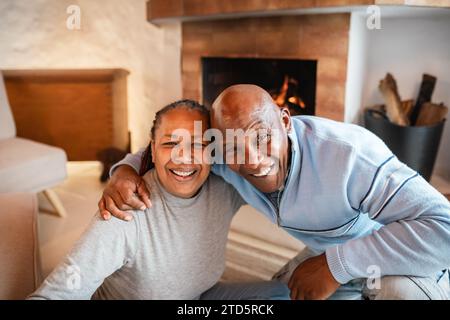 Happy African senior couple smiling into the camera in warmth cozy house Stock Photo