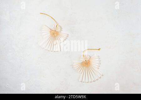 Two Christmas paper angels on white textured background. Top view, flat lay. Stock Photo