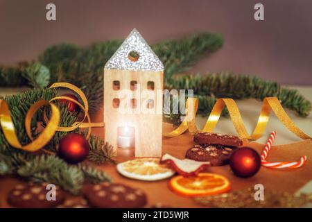 Christmas decorations with burning candle, baubles and dried fruits on dark background. New year concept. Selective focus. Stock Photo