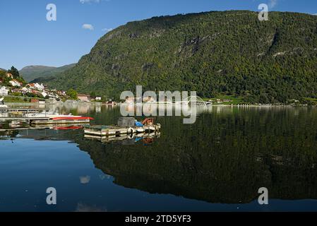 Colorful buildings along the hill side and their reflections  on the lake in Sogndal, Norway. Stock Photo