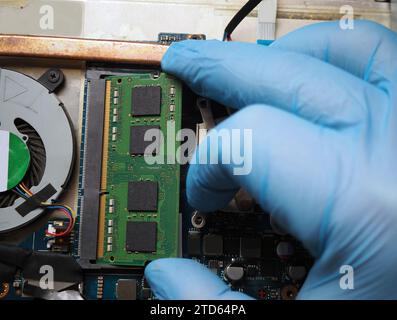 Technician inserting a ram module to the computer. Stock Photo