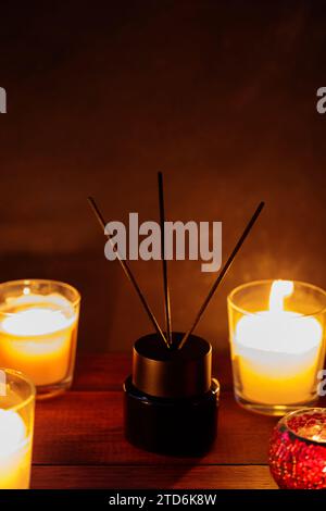 Serene Aromatherapy Setting: Reed Diffuser and Burning Candles on Wooden Table Stock Photo