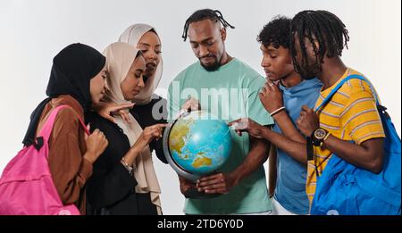 A diverse group of students is gathered around a globe, engrossed in exploration and study, their vibrant energy captured against a pristine white Stock Photo