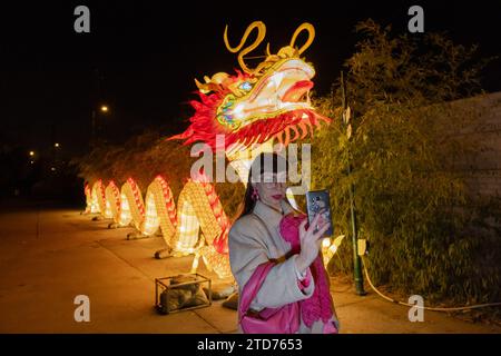 (231217) -- BUDAPEST, Dec. 17, 2023 (Xinhua) -- A visitor takes selfies at the Year of the Dragon Lantern Festival in Budapest Zoo in Budapest, Hungary, Dec. 16, 2023. A lantern festival opened in Budapest on Saturday as part of the celebrations for the upcoming Chinese Lunar New Year, the Year of the Dragon. The festival showcases hundreds of heritage lantern art pieces from Zigong, a city in southwest China's Sichuan Province known for this traditional art form. (Photo by Attila Volgyi/Xinhua) Stock Photo