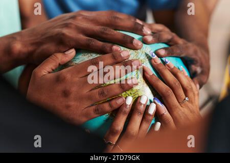Close up of diverse teenagers' hands delicately exploring a globe, capturing the essence of curiosity and exploration in their tactile engagement with Stock Photo