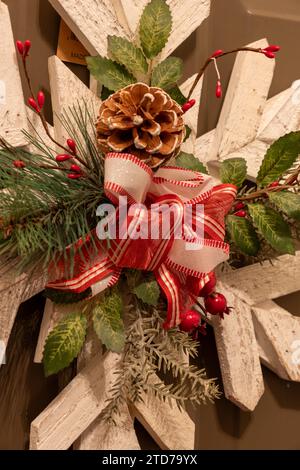 Close up view of a wooden snowflake holiday wreath decoration on a brown painted traditional residential door Stock Photo