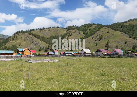 Village landscape at the foot of green hills in the Altai Republic, Russia Stock Photo