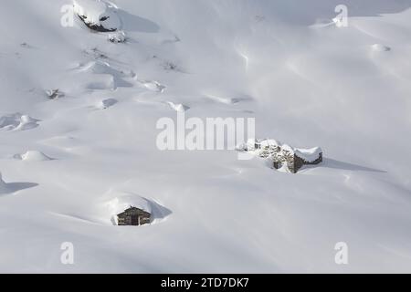 Ruined buildings in deep snow, high mountains Stock Photo