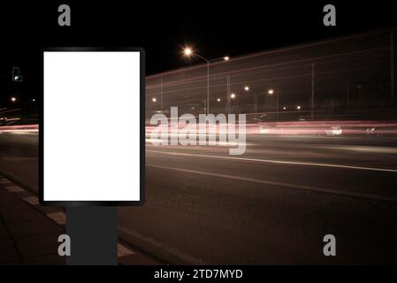 Billboard, banner, empty, white at a bus stop on the highway during the twilight with city background with clipping path on screen.- can be used for d Stock Photo