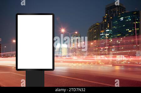 Billboard, banner, empty, white at a bus stop on the highway during the twilight with city background with clipping path on screen.- can be used for d Stock Photo