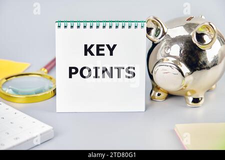 KEY POINTS A word, a text written on a notebook next to a piggy bank, a magnifying glass, a calculator, stickers Stock Photo