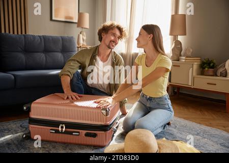 Happy loving couple looking on each other with adoration preparing for travel Stock Photo