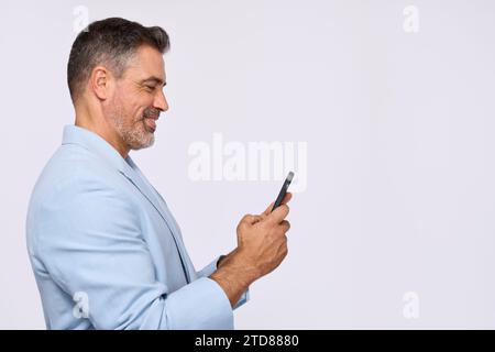 Smiling older business man wearing suit using phone, side view, copy space. Stock Photo
