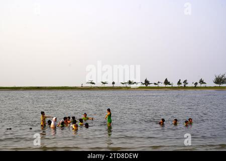 People spending the end of the day at the Ancol Beach during the school holiday season. Stock Photo