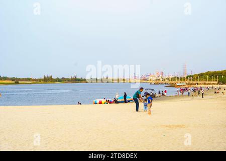 People spending the end of the day at the Ancol Beach during the school holiday season. Stock Photo