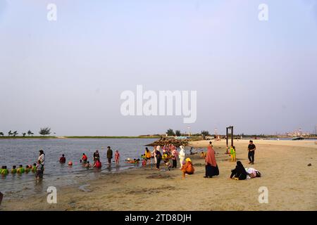 People spending the end of the day at the Ancol Beach during the school holiday season. Stock Photo