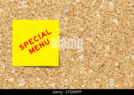 Yellow note paper with word special menu on cork board background with copy space Stock Photo